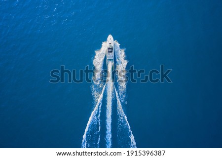 Motor boat in the sea. Aerial view luxury motor boat. Drone view of a boat sailing. Top view of a white boat sailing to the blue sea. Travel - image. Royalty-Free Stock Photo #1915396387