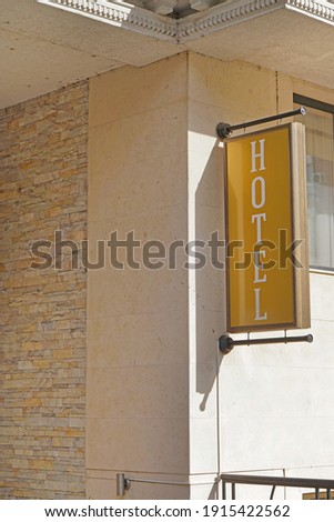 Vertical gold sign at hotel building sunny day