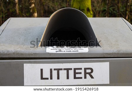 Litter sign on a silver steel trash can or bin in the countryside park