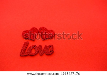 Valentine's day red background with wooden hearts and the word love. Place for inscriptions, advertising