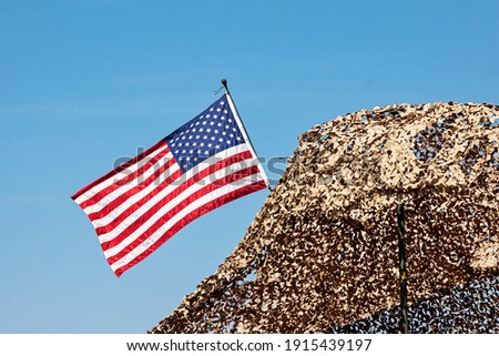 United States flag over military camouflage material