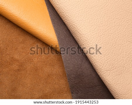 Different colors natural leather textures samples on brown background Royalty-Free Stock Photo #1915443253