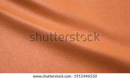 Genuine orange cattle leather texture background. Macro photo