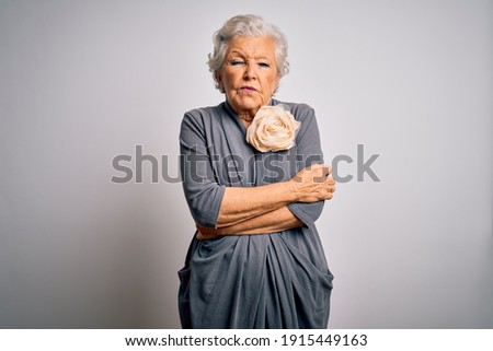 Senior beautiful grey-haired woman wearing casual dress standing over white background shaking and freezing for winter cold with sad and shock expression on face