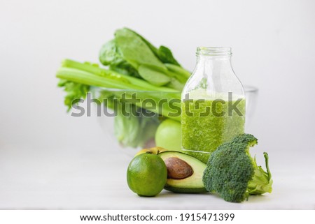 glass with green healthy smoothie, nutritious breakfast, vegetarian food, raw vegetables in the morning, broccoli, avocado, celery, salad, kiwi apple, lime. healthy eating for the whole family, diet Royalty-Free Stock Photo #1915471399