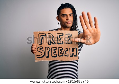 Young african american man with dreadlocks holding banner with free speech message protest with open hand doing stop sign with serious and confident expression, defense gesture