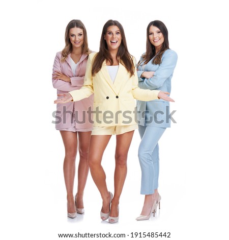 Picture of three women in pastel suits posing over white background