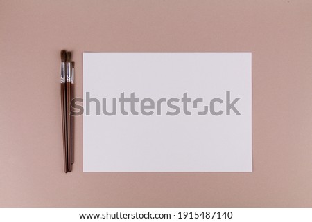 a brushes for painting on the table near a white sheet of paper