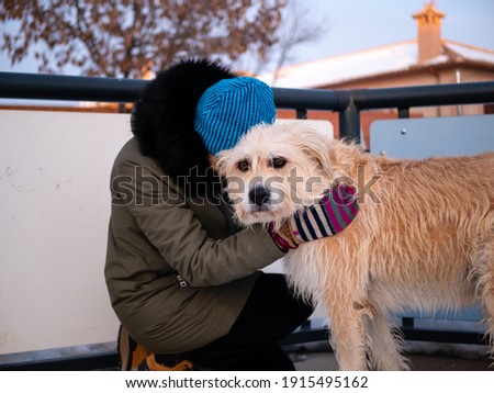 Attractive blonde woman with blue eyes, in winter, posing with her shepherd dog