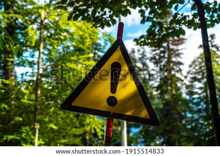 yellow warning sign in forest