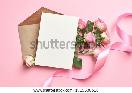 Greeting card mockup with copy space, pink ribbon and roses flowers on paper background