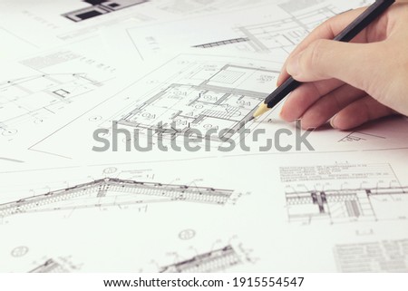 An architect engineer creates a working drawing sketch for building a house building. Architectural design projects concept. Engineering and architecture drawings Royalty-Free Stock Photo #1915554547