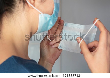 Woman puts two surgical face masks