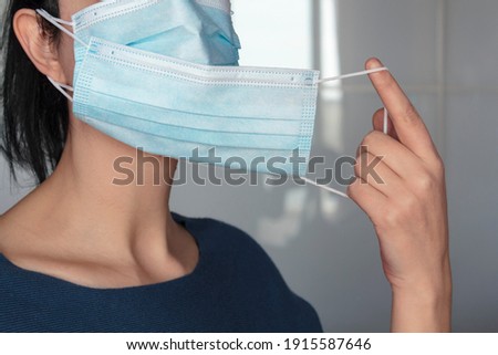 Woman puts a second protective mask