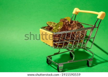 shopping cart filled with gold coins set against a blue background