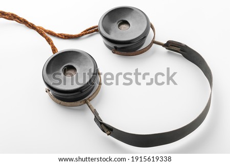Old headphones with fabric wire. Top view intazhnye headphones on a white background. The concept of ancient radio engineering. Selective soft focus. 
