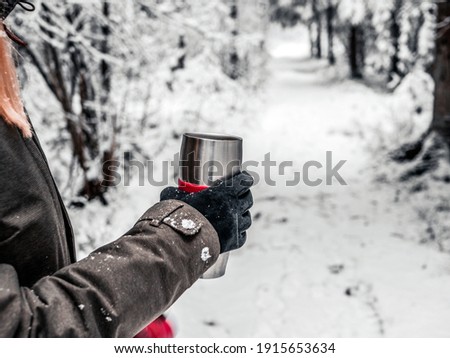 Tea keeps me warm outside. Young woman enjoying hot drink outdoors in winter. Spruce Tree Forest Covered by Snow in Winter Landscape . image for wallpaper