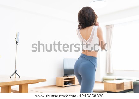 Beautiful young asian woman exercising in the room,taken pictures of her self,back view