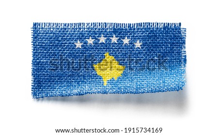 Kosovo flag on a piece of cloth on a white background