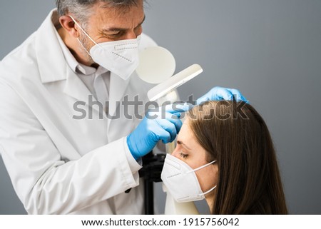 Dermatologist Doctor Checking Woman Hair For Dandruff In Face Mask