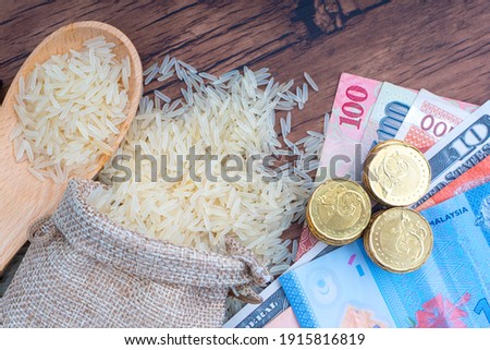 Coins, Banknotes and Rice on wooden background. Zakat concept. Zakat is a form of alm-giving as a religious obligation 