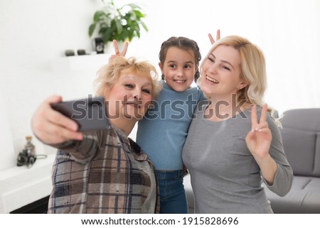 A little girl, mother and grandmother at home.