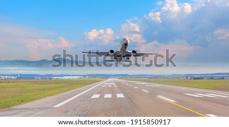 White Passenger plane fly up over take-off runway from airport  Royalty-Free Stock Photo #1915850917