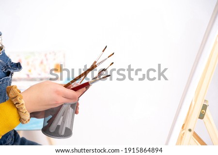 Hands holding paintbrushes on white background, copy space