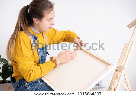 Woman artist preparing canvas for painting
