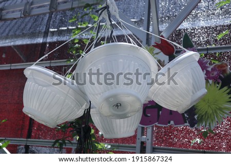 Empty white flower pots hung by wire rope