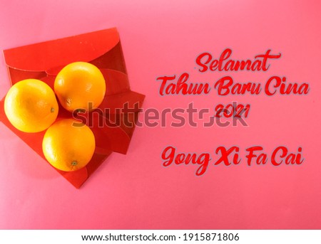 A malay and chinese quotes "Selamat Tahun Baru Cina 2021 and Gong Xi Fa Cai" with three oranges and three chinese ang pao packets on red background. (Translation: Happy chinese new year 2021)
