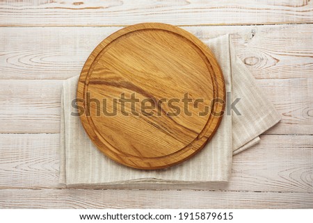 Empty pizza board and canvas tablecloth on white wooden deck