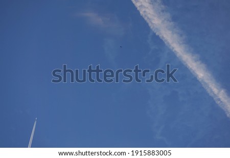 White trails from commercial airplanes, another plane flying, chemtrails conspiracy theory concept