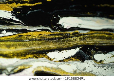In the photo, there is a shimmering golden black and white color, combined with a gradation and a strange, abstract and marble-like pattern.