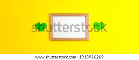 Green paper hearts flat lay top view banner on wooden frame in the centre with white copy space on yellow background Saint Patrick's Day 17 march traditional spring celebration holiday and good luck