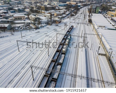 Snow-covered freight trains on rails in Kiev. Aerial drone view. Winter snowy morning.