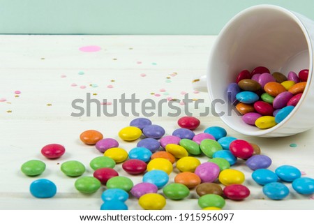Colored candy bonbons scattered on white wooden board background Studio Photo