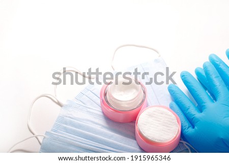 Beauty accessories on white background. Blue gloves, masks, and cream. High-quality photo