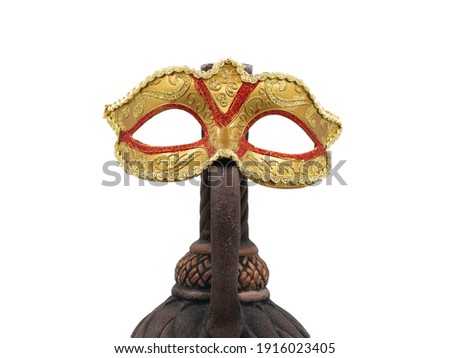 A traditional golden Venetian carnival mask next to an ornate clay wine bottle. The photo is isolated on a white background. The concept of the annual Brazilian festival.