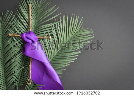 cross with purple sash and palms on black background Royalty-Free Stock Photo #1916032702