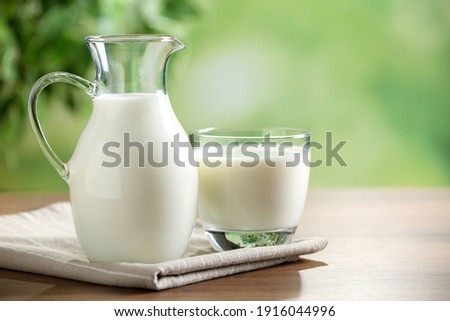 Fresh milk on wooden table against blurred background, space for text Royalty-Free Stock Photo #1916044996