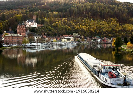 
A barge carries cargo along the Main river against the backdrop of the city of Miltenberg and its castle