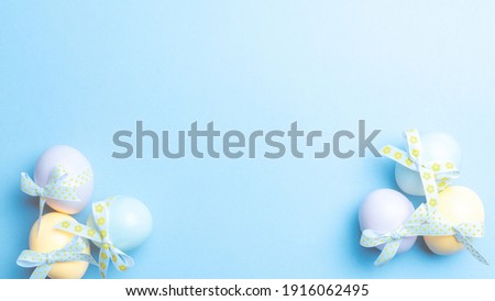 Easter eggs isolated. Colorful egg with tape ribbon on pastel blue background in Happy Easter decoration. Flat lay, top view