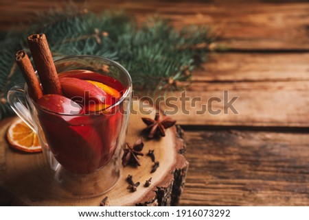 Tasty aromatic mulled wine on wooden table. Space for text