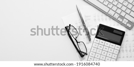 Calculator on financial statement and balance sheeet on desk of auditor. Concept of accounting and audit business. Royalty-Free Stock Photo #1916084740