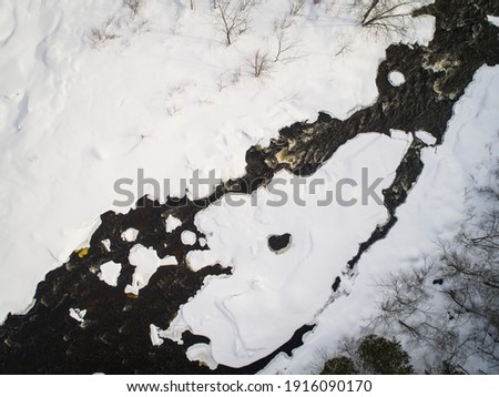 Aerial view of river and flowing waters in winter