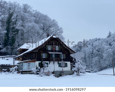 Idyllic Swiss alpine mountain huts and traditional Swiss rural architecture dressed in winter clothes and in a fresh snow cover on the slopes of Mountain Rigi, Weggis - Canton of Lucerne, Switzerland