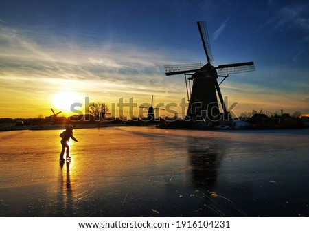 Skaters near windmills in Kinderdijk, the Netherlands 