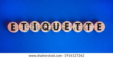 Etiquette symbol. Concept word 'etiquette' on wooden circles on a beautiful blue background.  