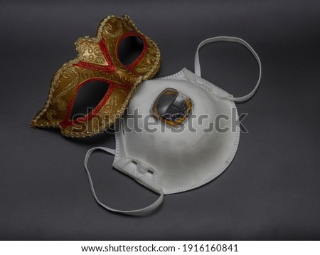 White medical (aerosol) and traditional golden carnival Venetian mask on a black background. Preparation for the Brazilian Festival and Mardi Gras. The concept of opening the danger of mass events.